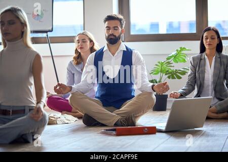 Junge Kollegen, die Yoga machen und sich im Büro konzentrieren Stockfoto