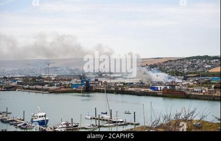 Newhaven UK 8. August 2020 - Rauch steigt über Newhaven Port in East Sussex als Feuerwehrleute kämpfen ein Feuer in der Nähe des Bahnhofs : Credit Simon Dack / Alamy Live News Stockfoto