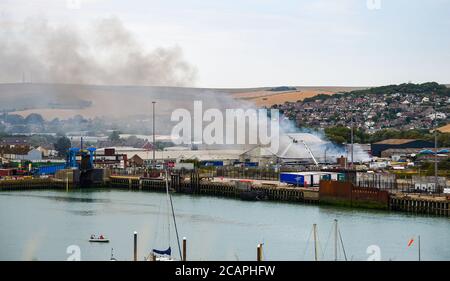 Newhaven UK 8. August 2020 - Rauch steigt über Newhaven Port in East Sussex als Feuerwehrleute kämpfen ein Feuer in der Nähe des Bahnhofs : Credit Simon Dack / Alamy Live News Stockfoto