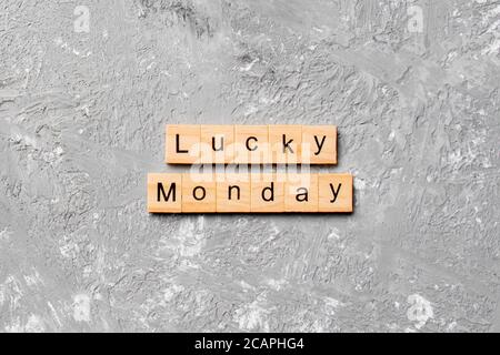 Lucky monday Wort auf Holzblock geschrieben. Lucky monday Text auf Zementtisch für Ihr Design, Konzept. Stockfoto