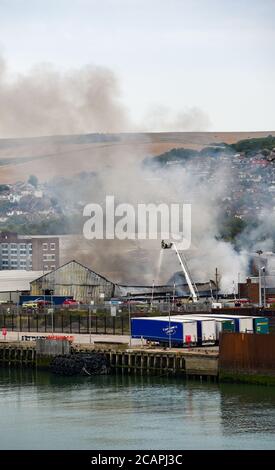 Newhaven UK 8. August 2020 - Rauch steigt über Newhaven Port East Sussex auf, als Feuerwehrleute in einer Fabrik in der Nähe des Bahnhofs gegen einen Brand kämpfen : Credit Simon Dack / Alamy Live News Stockfoto