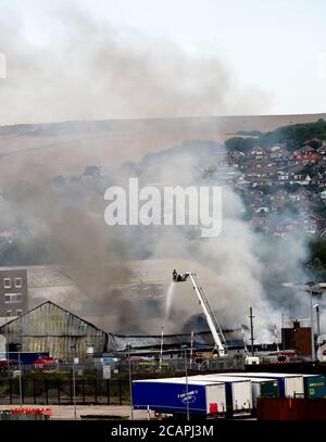 Newhaven UK 8. August 2020 - Rauch steigt über Newhaven Port East Sussex auf, als Feuerwehrleute in einer Fabrik in der Nähe des Bahnhofs gegen einen Brand kämpfen : Credit Simon Dack / Alamy Live News Stockfoto