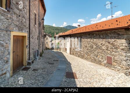 Enge Gassen mit Steinhäusern in dem kleinen Bergdorf Bassola, Weiler Armeno oberhalb des Ortasees in der Provinz Novara, Piemont, Italien Stockfoto