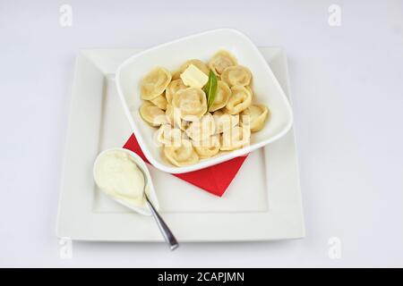 Knödel mit einem Stück Butter und saurer Sahne auf Ein weißer Hintergrund Stockfoto