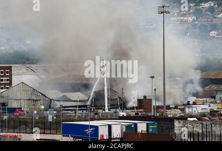 Newhaven UK 8. August 2020 - Rauch steigt über Newhaven Port East Sussex auf, als Feuerwehrleute in einer Fabrik in der Nähe des Bahnhofs gegen einen Brand kämpfen : Credit Simon Dack / Alamy Live News Stockfoto