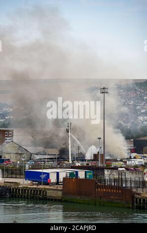 Newhaven UK 8. August 2020 - Rauch steigt über Newhaven Port East Sussex auf, als Feuerwehrleute in einer Fabrik in der Nähe des Bahnhofs gegen einen Brand kämpfen : Credit Simon Dack / Alamy Live News Stockfoto