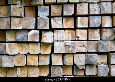 Stapel von Holzstangen im Lager. Gestapelte Holzbalken von quadratischen Abschnitt. Stockfoto