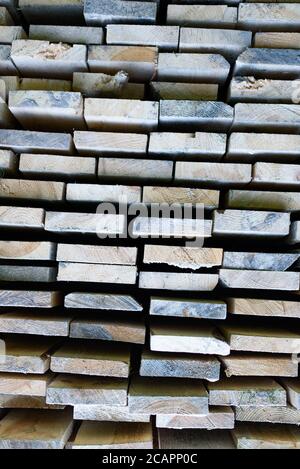 Stapel von Brettern in einem Lager. Gestapelte Holzbalken von rechteckigem Abschnitt. Stockfoto
