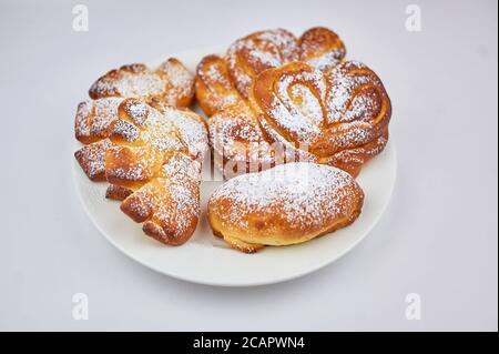 Süßes Brötchen auf einem Teller mit weißem Hintergrund Stockfoto