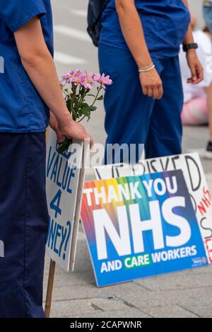 Basildon, Essex, Großbritannien. August 2020. In Basildon fand ein demonstrationszug statt, der gegen den Ausschluss des Personals des nationalen Gesundheitsdienstes aus der Lohnerhöhung des öffentlichen Sektors protestierte. Die Demonstranten versammelten sich im Basildon Hospital, bevor sie in das Stadtzentrum von Basildon marschierten, wo viele Blumen und Bänder für die vielen Gesundheitshelfer, die durch die COVID-19 Coronavirus-Pandemie verloren wurden, hinlegten Stockfoto