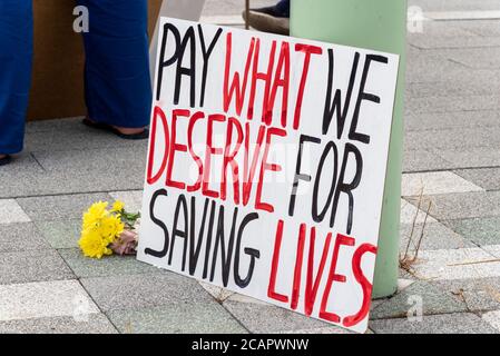 Basildon, Essex, Großbritannien. August 2020. In Basildon fand ein demonstrationszug statt, der gegen den Ausschluss des Personals des nationalen Gesundheitsdienstes aus der Lohnerhöhung des öffentlichen Sektors protestierte. Die Demonstranten versammelten sich im Basildon Hospital, bevor sie in das Stadtzentrum von Basildon marschierten, wo viele Blumen und Bänder für die vielen Gesundheitshelfer, die durch die COVID-19 Coronavirus-Pandemie verloren wurden, hinlegten Stockfoto