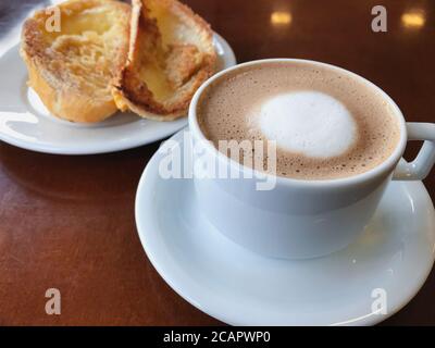 Brasilianisches Frühstück. Cappuccino Tasse und geröstetes Brot mit Butter Hintergrund Stockfoto