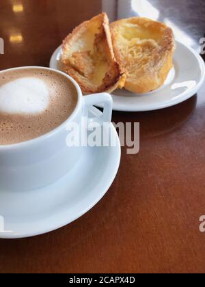 Brasilianisches Frühstück. Cappuccino Tasse und geröstetes Brot mit Butter Hintergrund Stockfoto