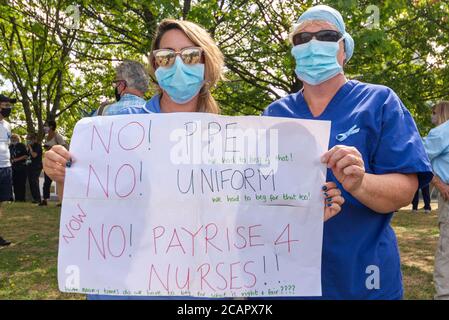 Basildon, Essex, Großbritannien. August 2020. In Basildon fand ein demonstrationszug statt, der gegen den Ausschluss des Personals des nationalen Gesundheitsdienstes aus der Lohnerhöhung des öffentlichen Sektors protestierte. Die Demonstranten versammelten sich im Basildon Hospital, bevor sie in das Stadtzentrum von Basildon marschierten, wo viele Blumen und Bänder für die vielen Gesundheitshelfer, die durch die COVID-19 Coronavirus-Pandemie verloren wurden, hinlegten Stockfoto