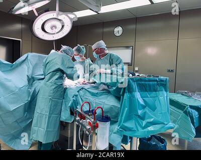 In einem großen Operationssaal wird eine Operation durchgeführt Von zwei Ärzten Stockfoto