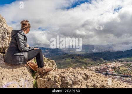 Junge Frau Blick auf Ansicht PF stürmischen Himmel von oben Der Felsenspitze jaen spanien Stadt unten Stockfoto