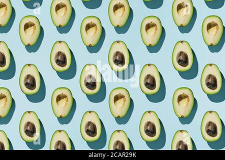 Muster der Schnitt Avocado auf blauem Hintergrund, gesunde Ernährung Konzept Stockfoto