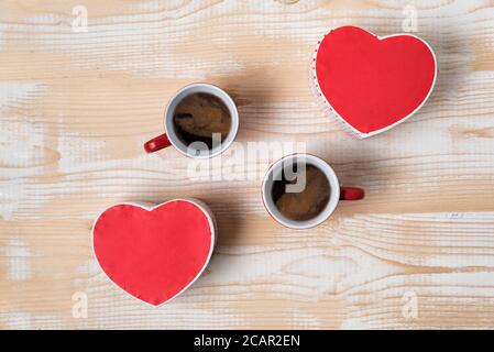 Zwei rote Tassen Kaffee und herzförmige Boxen. Datum, Valentinstag. Draufsicht Stockfoto