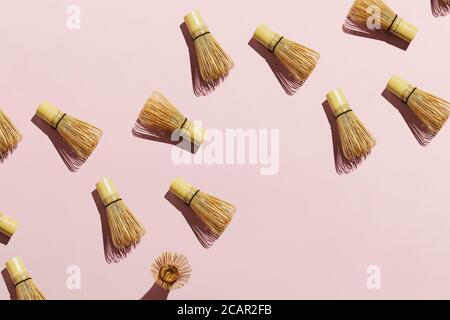 Flatlay aus Bambus Matcha Tee Whisks auf rosa Pastell Hintergrund Stockfoto