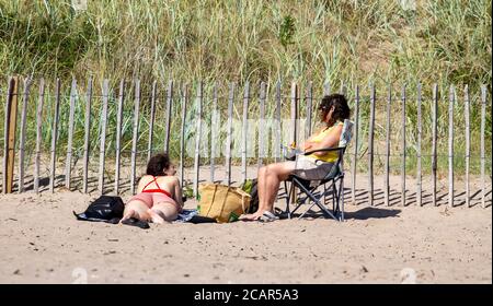 Dundee, Tayside, Schottland, Großbritannien. August 2020. UK Wetter: Die Hitzewelle zieht sich weiter durch Nordostschottland mit einer maximalen Temperatur von 25 Grad Anwohner nehmen den Tag aus, um das herrliche Wetter Sonnenbaden zu genießen und mit Familie und Freunden am Broughty Ferry Strand in Dundee während der Covid-19 Phase 3 entspannte Sperrbeschränkungen zu sein. Kredit: Dundee Photographics/Alamy Live Nachrichten Stockfoto