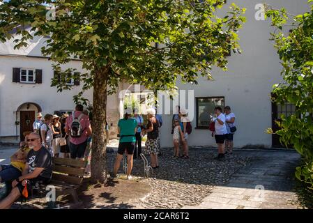 Burghausen, Deutschland-August 8,2020: Eine Gruppe von Touristen hört einem Führer am Eingang zu einem Schloss zu Stockfoto