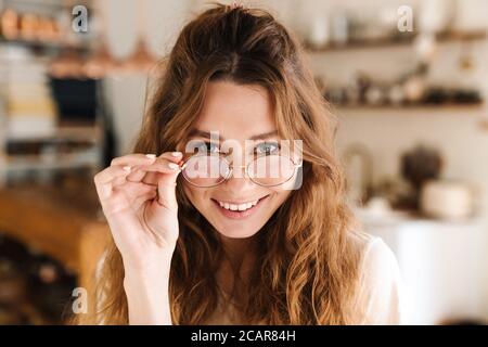 Heiter schöne Mädchen Grimacing während in der Küche stehen, Blick auf die Kamera Stockfoto