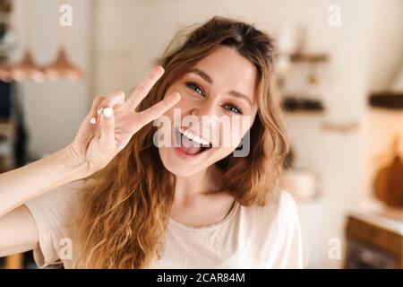 Heiter schöne Mädchen Grimacing während in der Küche stehen, Blick auf die Kamera Stockfoto