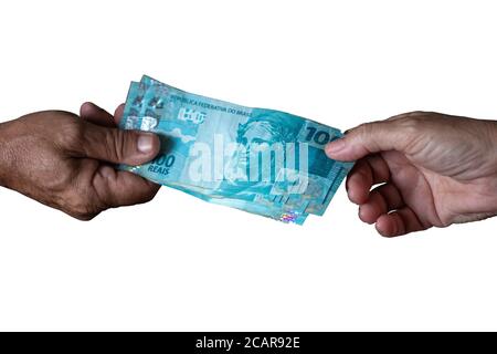 Brasilianische Banknoten. Einhundert Reien. Hand des Mannes und Hand der Frau, die hundert reais Noten mit weißem Hintergrund hält Stockfoto