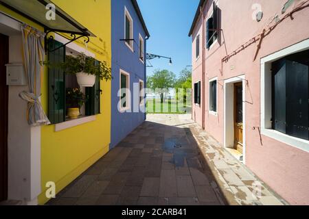 Insel Burano, Lagune von Venedig, Venedig, Italien, schmale Straße zwischen den typischen farbigen Häusern des Stadtzentrums Stockfoto