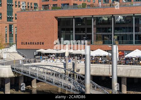 Die Elbarkaden an der Elbtorpromenade in der Hamburger HafenCity mit gut besuchter Gastronomie an einem sonnigen Tag. Stockfoto