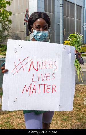 Schwarze Frauen am NHS protestieren gegen die Verfehlung der Gehaltserhöhung im öffentlichen Sektor und um Mitarbeiter zu ehren, die durch COVID-19 getötet wurden. „Play on black lives matter“-Schriftzug Stockfoto