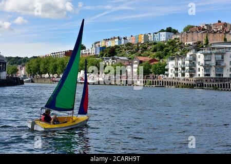 Bristol City Docks mit kleinen Boot Segeln und Reihenhäuser von Clifton Wood auf Hügel im Hintergrund, Großbritannien Stockfoto