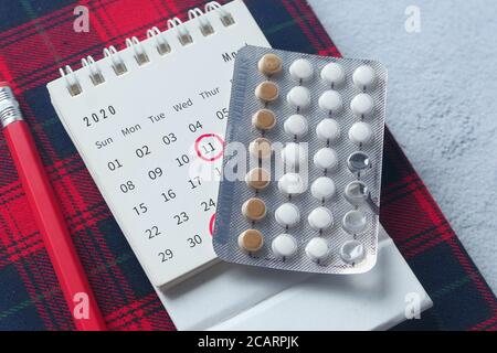 Geburtenkontrolle Pillen, Kalender und Notizblock auf dem Tisch Stockfoto