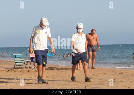 Punta Umbria, Huelva, Spanien - 7. August 2020: Die Strandwache der Junta de Andalucia kontrolliert die soziale Distanzierung und den Einsatz von Schutzmaske Stockfoto