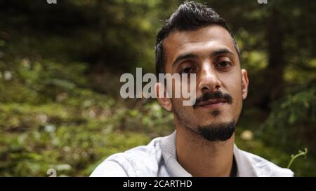 Porträt von jungen gut aussehenden bärtigen Brünette Mann Blick auf die Kamera Stockfoto