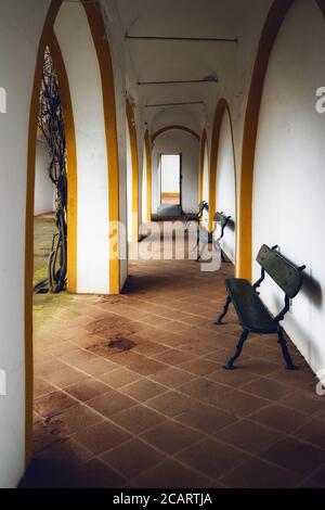 Alleen und Veranden von Evora, der Hauptstadt der Region Alentejo in Portugal, berühmt für ihre traditionellen weißen und gelben Häuser. Detail der Arkaden und b Stockfoto