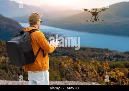 Ein Mann steht auf einem Berg und kontrolliert Eine Drohne Stockfoto