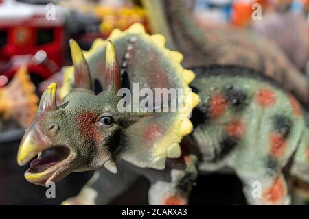 Plastikdinosaurier (Triceratops) auf einem Flohmarkt in Hamburg. Makrofotografie des Kopfes mit einem verwacklungsunscharfen Verlauf. Stockfoto