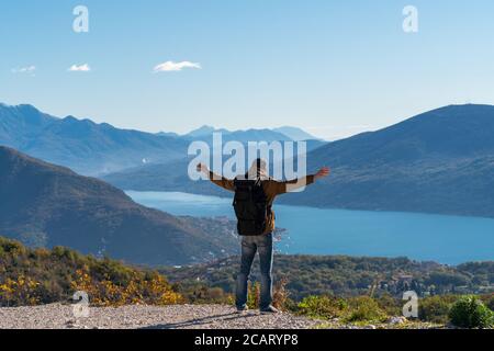 Ein Reisender mit Rucksack steht auf der Oberseite Der Berg Stockfoto