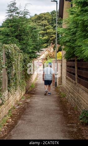 Älterer Mann in Shorts und auf dem Weg durch eine Gasse Stockfoto