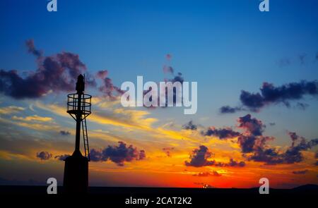 Leuchtturm Silhouette bei Sonnenuntergang im Hafen von Alghero Stockfoto