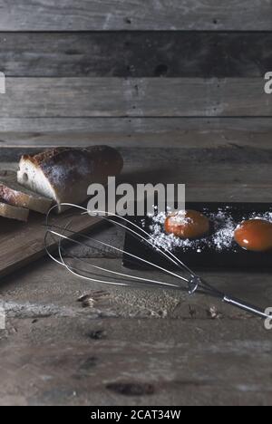 Vertikale Aufnahme eines frisch geschnittenen Brotes und Eigelb Auf einem rustikalen Holztisch Stockfoto