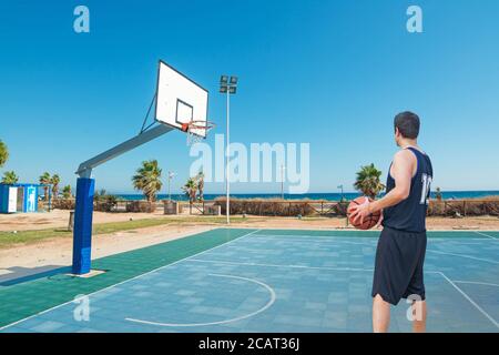 Basketballspieler steht auf einem blauen Spielplatz Stockfoto