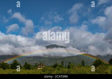Wolken in den Bergen mit Regenbogen Stockfoto
