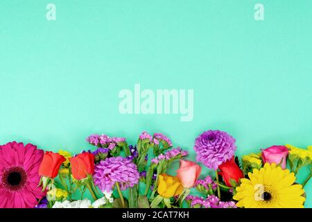 Blumen Frühling Hintergrund. Schöne Blumen auf türkisfarbenem Hintergrund. Blumenmuster mit Blütenblättern auf türkisfarbenem Hintergrund. Blumenrahmen. Stockfoto