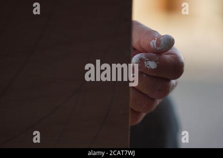 Nahaufnahme der Hand eines Künstlers mit weißer getrockneter Farbe Es hinter der Leinwand Stockfoto