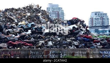 Ein Stapel zerschmetterte Fahrzeuge und anderes Metall sitzen in einem riesigen Stapel auf einem Metallschrottplatz in Victoria, British Columbia, Kanada und warten auf Recycling. Im Stockfoto