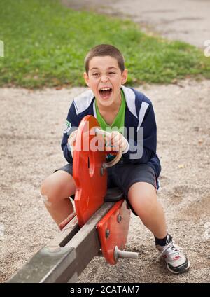 Young Boy spielt auf einer Seesaw in einem Park Stockfoto