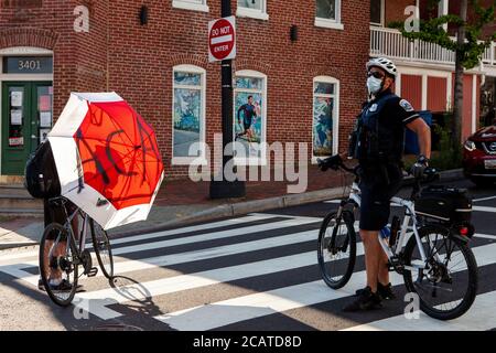 Washington, DC, USA. August 2020. Im Bild: Ein Polizist der Metropolitan Police (DC Police) gibt vor, dass der Protestierende mit einem Schirm, der sagt, dass ACAB nicht da ist. Kredit: Allison C Bailey/Alamy. Kredit: Allison Bailey/Alamy Live Nachrichten Stockfoto