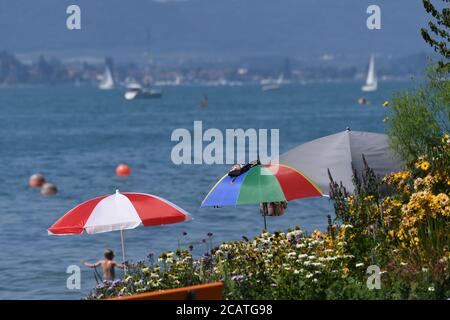 Sipplingen Am Bodensee, Deutschland. August 2020. Sonnenschirme stehen an der Promenade am Ufer des Bodensees. Die Behörden appellieren an Touristen, sich an die Regeln der Entfernung zu halten. Quelle: Felix Kästle/dpa/Alamy Live News Stockfoto